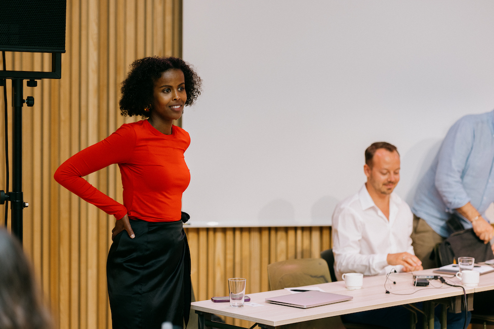 Foto av Zubeida som står foran en forsamling og snakker. Foto: Julie Hrnčířová